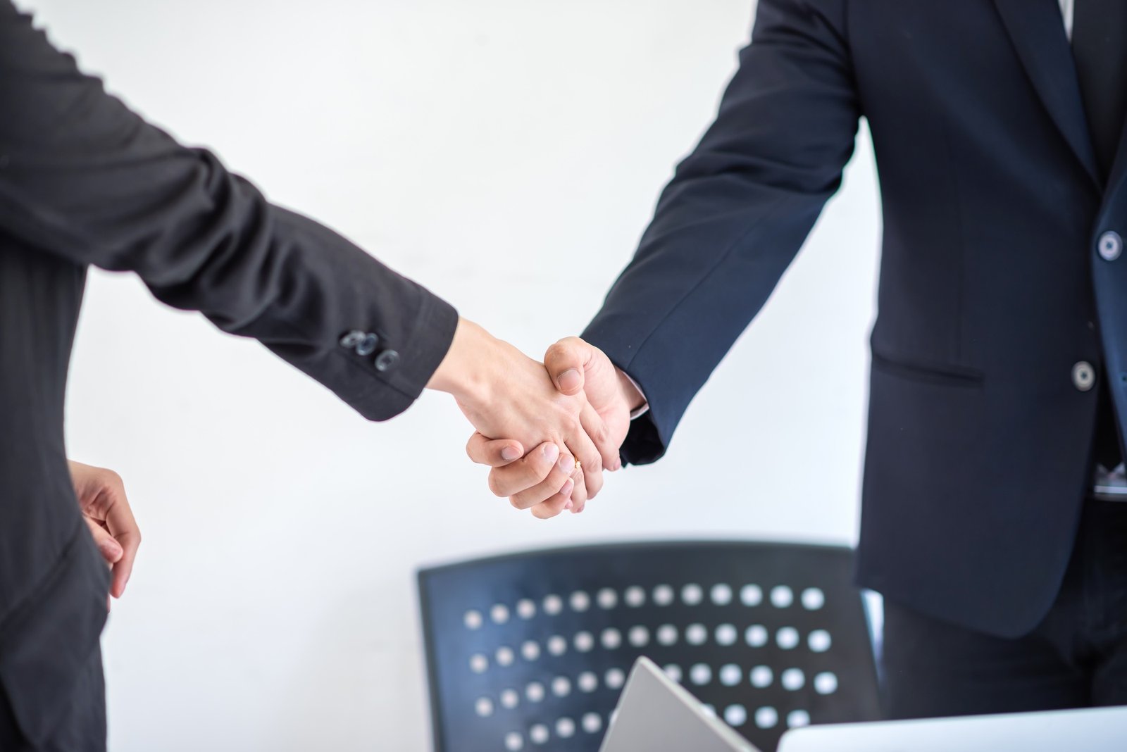 Businessman and businesswoman shaking hands at the end of the meeting at the office.